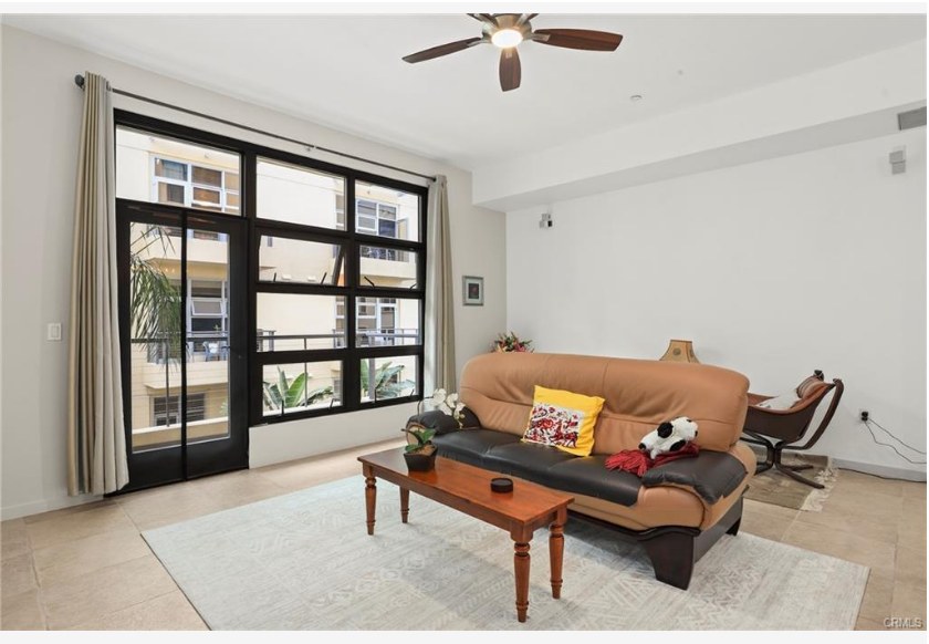 133 The Promenade N #318 — living area with soaring ten-foot ceilings and oversized industrial windows