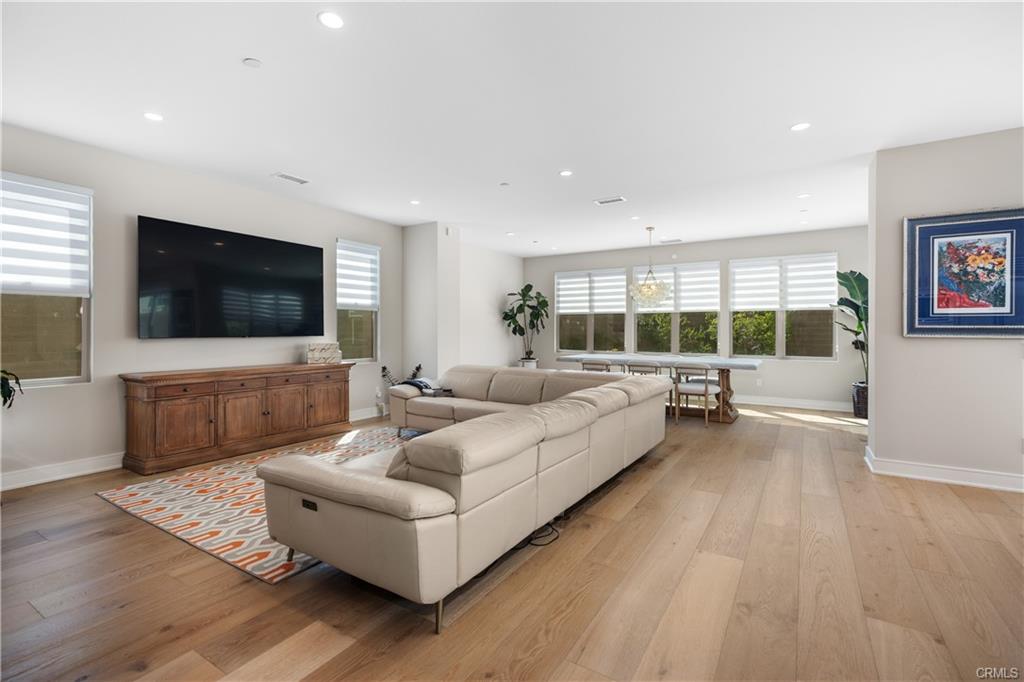 142 Sabbia — great room with wide-plank wood flooring open to the kitchen