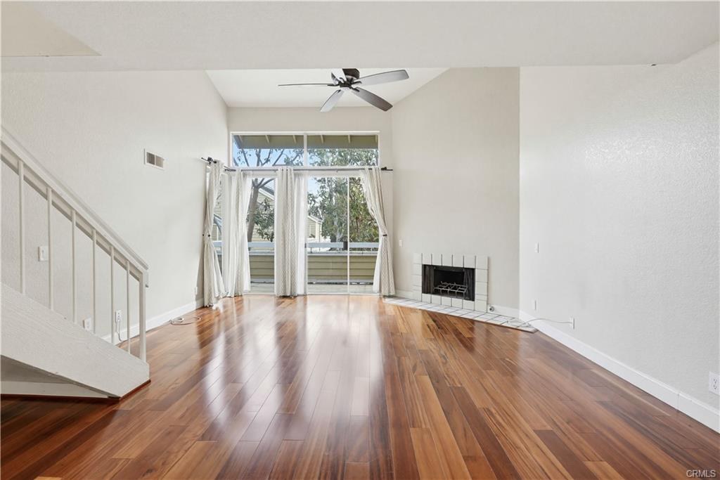 3650 S Bear St #77 — vaulted living room with gas fireplace and hardwood floors