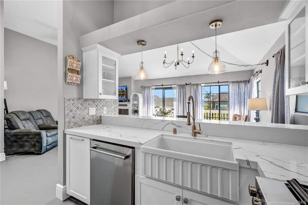 4682 Warner Ave #C304 — remodeled kitchen with quartz counters and farmhouse sink