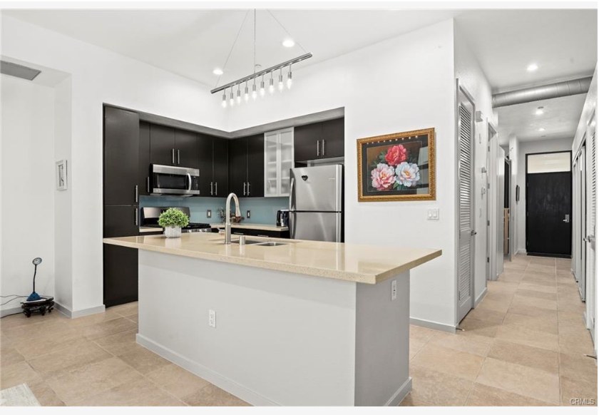 133 The Promenade N #318 — sleek kitchen with stainless steel appliances and oversized island