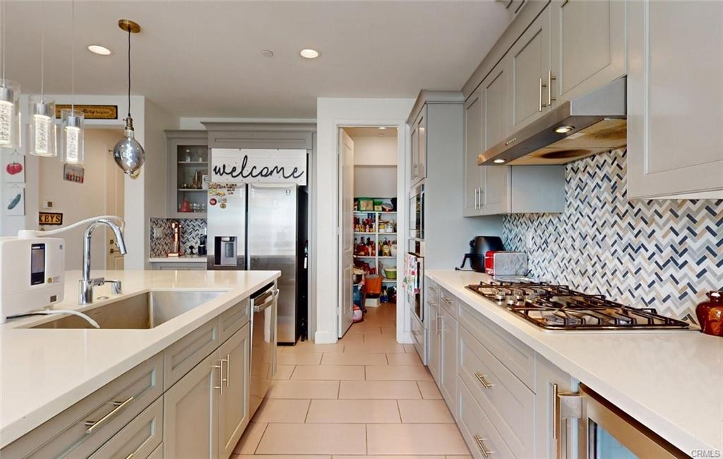 12954 Dahlia St — kitchen with gas range, tile backsplash, and walk-in pantry