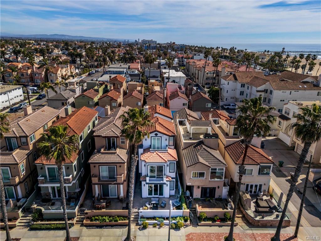 116 11th St — Aerial view over Downtown Huntington Beach rooftops toward the coastline