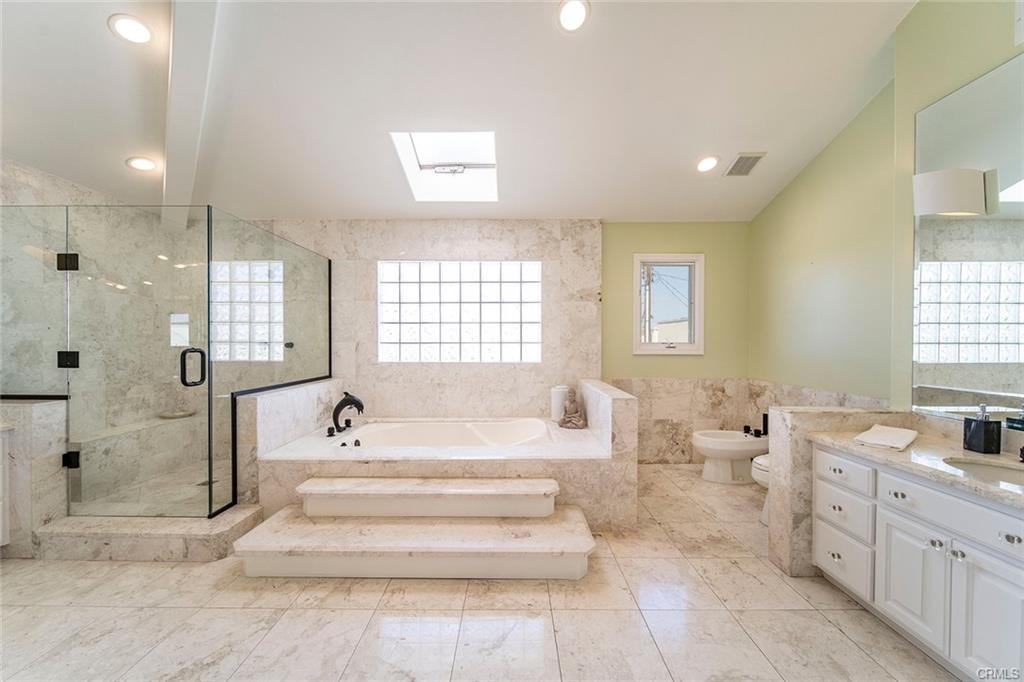 6063 Lido Ln — primary bath with soaking tub and stone finishes