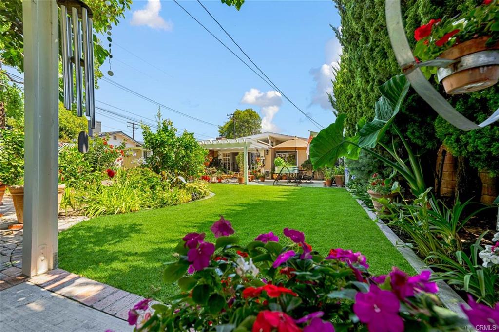 12231 Wilken Way — pergola-shaded sitting area surrounded by lush landscaping