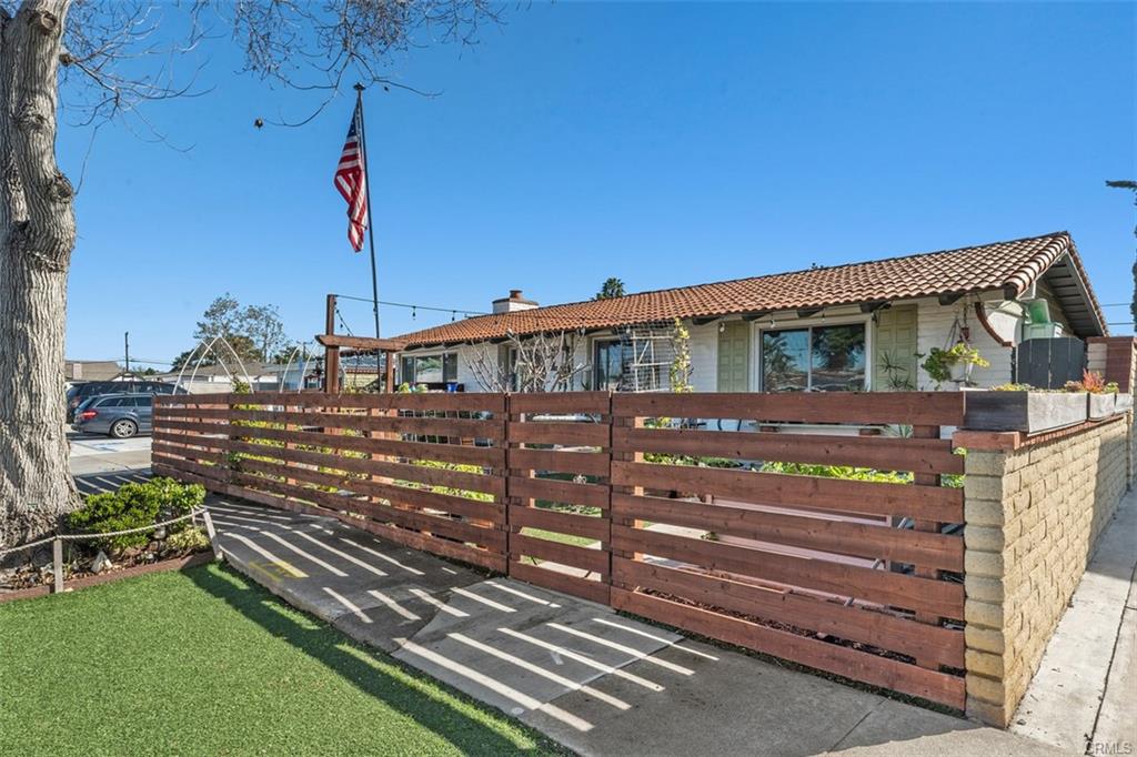 20292 Riverside Dr — front elevation with tile roof, flag, and horizontal fencing