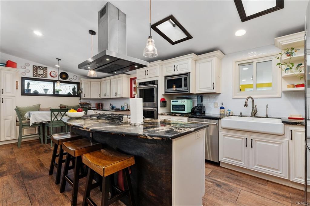 20292 Riverside Dr — kitchen with white cabinetry, stainless appliances, and island seating