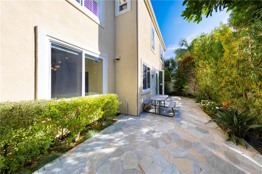 43 Lessay — private rear patio with stone hardscape and mature landscaping